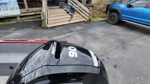 Slide: The Image of 2023 Tracker Pro Guide™ V-16 SC with Mercury 90 engine, parked near a blue truck. - 11