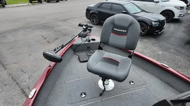 Slide: The Image of 2023 Tracker Pro Guide™ V-16 SC boat with swivel seat and trolling motor, parked on pavement. - 18