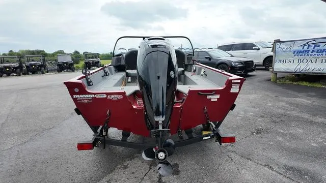 Slide: The Image of 2023 Tracker Pro Guide V-16 SC boat, red exterior, parked on a trailer in a lot. - 4