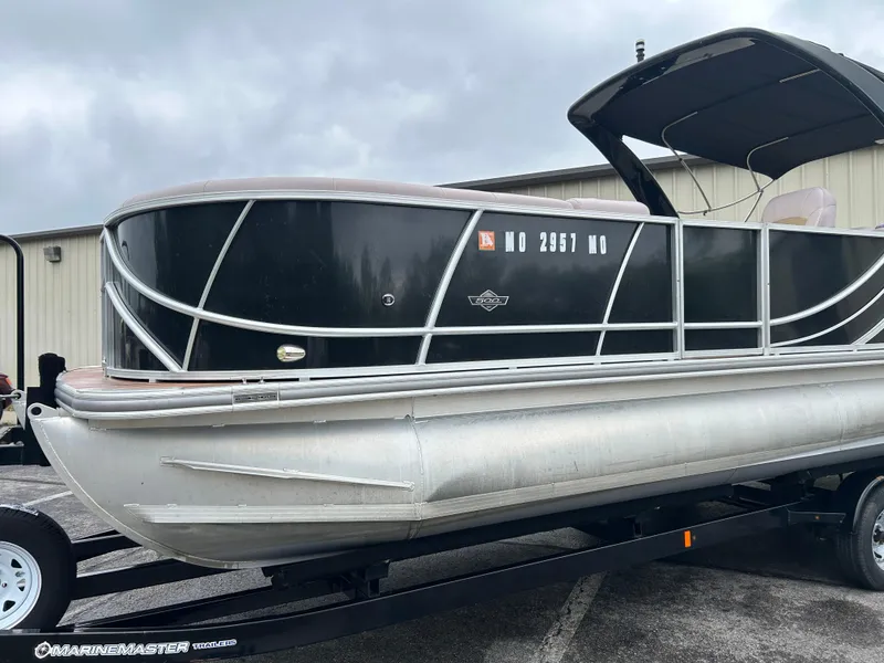 Slide: The Image of 2017 South Bay 525 RS Arch 3.0+ pontoon boat on trailer, parked outdoors. - 1
