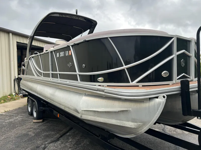 Slide: The Image of 2017 South Bay 525 RS Arch 3.0+ pontoon boat on trailer, parked outdoors. - 3
