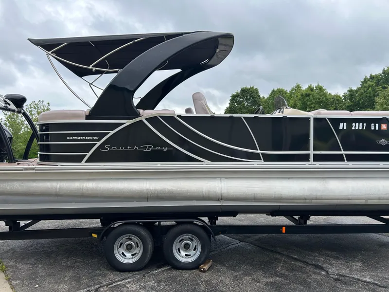 Slide: The Image of 2017 South Bay 525 RS Arch 3.0+ pontoon boat on trailer, black with sleek design. - 4