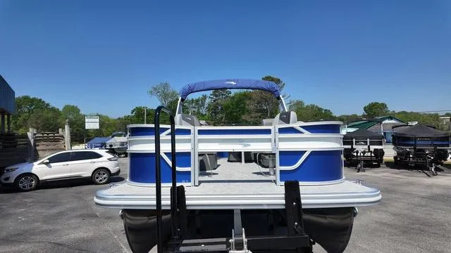 Slide: The Image of 2025 Bennington 20 SF Fish pontoon boat in a parking lot under clear blue sky. - 11