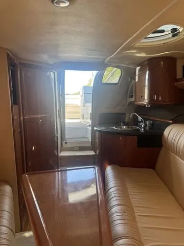 Slide: The Image of Interior of 2003 Cobalt 360 boat, featuring wood finishes and compact kitchen area. - 15