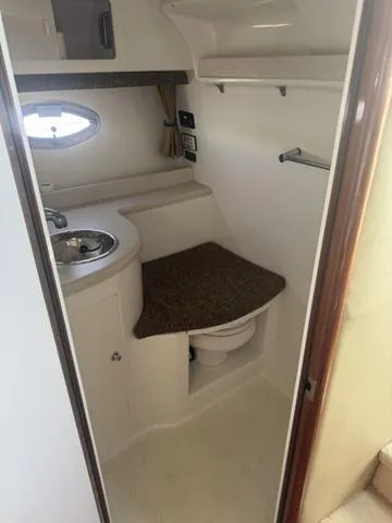 Slide: The Image of 2003 Cobalt 360 boat bathroom with sink, toilet, and storage shelf. - 16