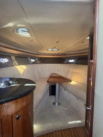 Slide: The Image of Interior of a 2003 Cobalt 360 boat with plush seating and wooden accents. - 17