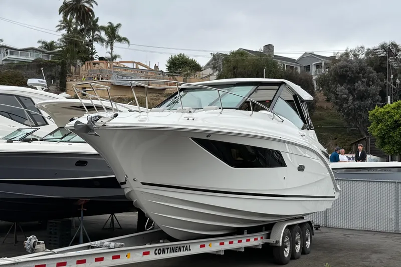 Slide: The Image of 2026 Sea Ray Sundancer 320 yacht on trailer, displayed outdoors with palm trees in background. - 1