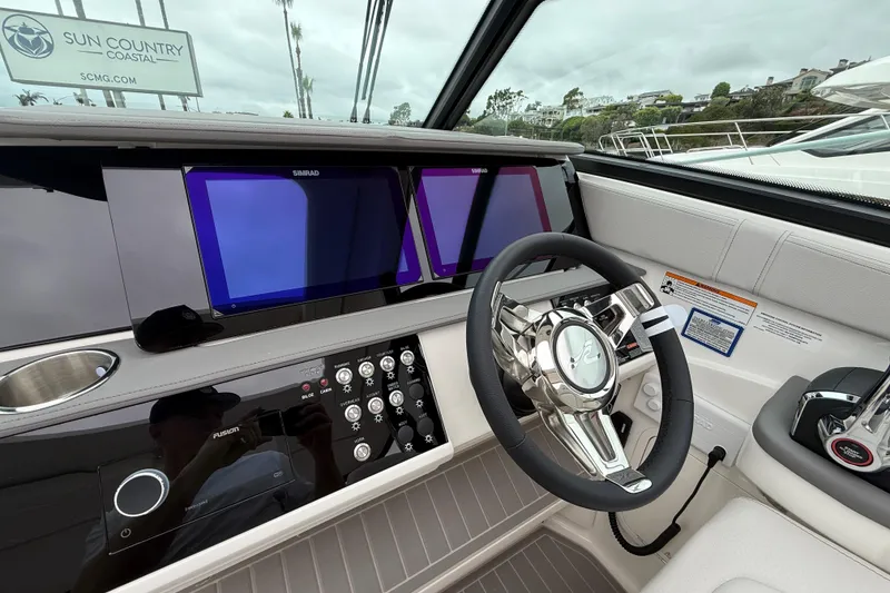 Slide: The Image of 2026 Sea Ray Sundancer 320 helm with modern controls and dual Simrad displays. - 11