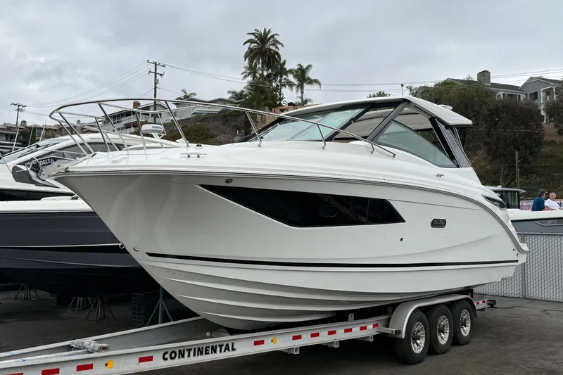 Slide: The Image of 2026 Sea Ray Sundancer 320 boat on a trailer, parked outdoors. - 2