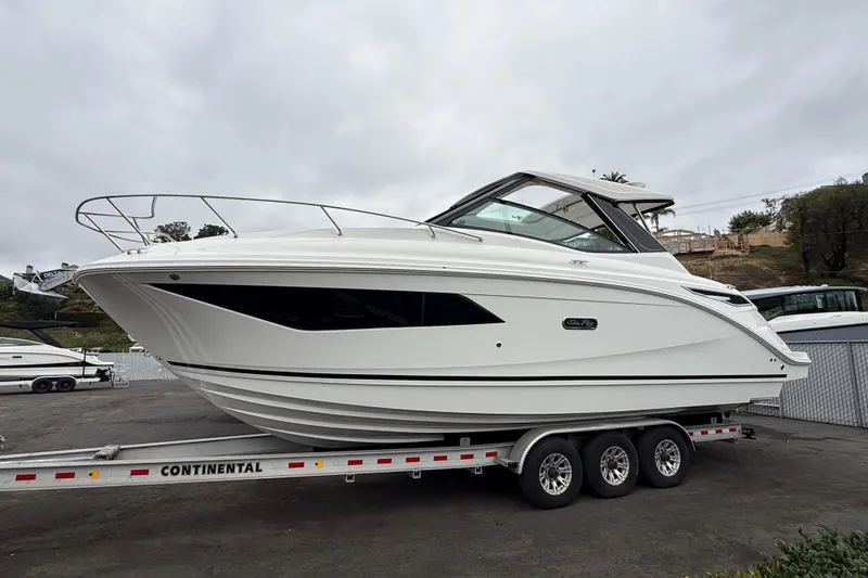 Slide: The Image of 2026 Sea Ray Sundancer 320 boat on trailer, sleek design, parked outdoors. - 3