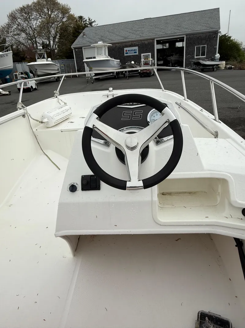 Slide: The Image of 2016 Boston Whaler 150 Super Sport boat interior with steering wheel and dashboard. - 11