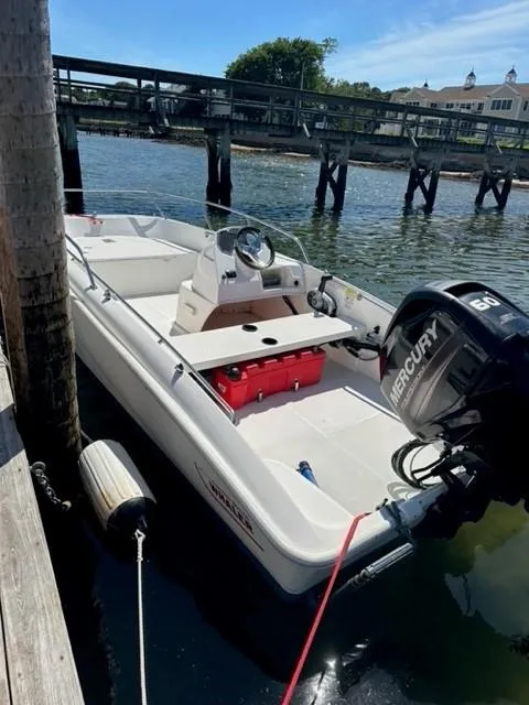 Slide: The Image of 2016 Boston Whaler 150 Super Sport boat docked by a wooden pier. - 4