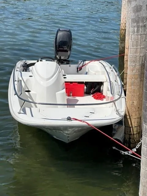 Slide: The Image of 2016 Boston Whaler 150 Super Sport boat docked on calm water. - 7
