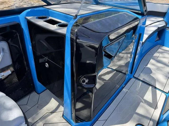Slide: The Image of 2022 Yamaha Boats 255XD interior, featuring sleek black and blue design with cup holders. - 15