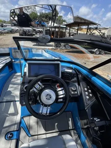 Slide: The Image of 2022 Yamaha Boats 255XD cockpit with steering wheel, touchscreen, and blue interior. - 21