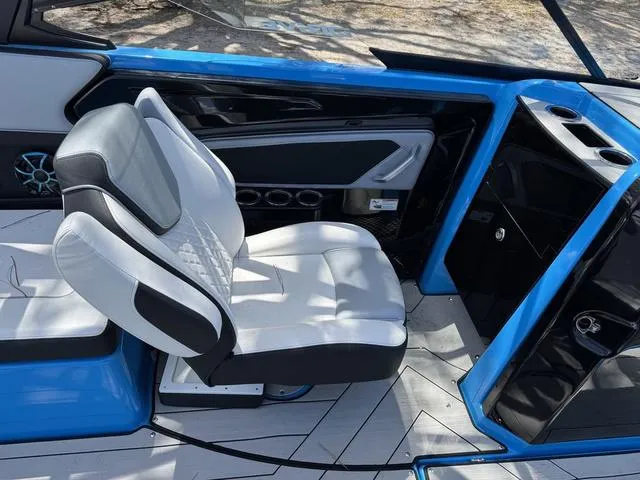 Slide: The Image of 2022 Yamaha Boats 255XD interior with white and black seating, blue accents, and modern design. - 6