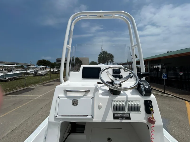 Slide: The Image of 2023 Shallow Sport 21 Sport boat console with steering wheel and controls. - 12