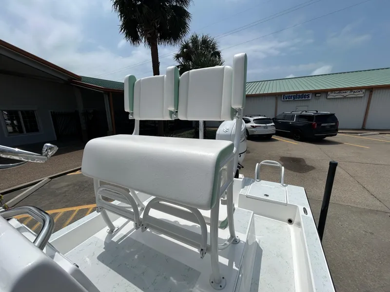 Slide: The Image of 2023 Shallow Sport 21 Sport boat with white seating, parked outdoors. - 13