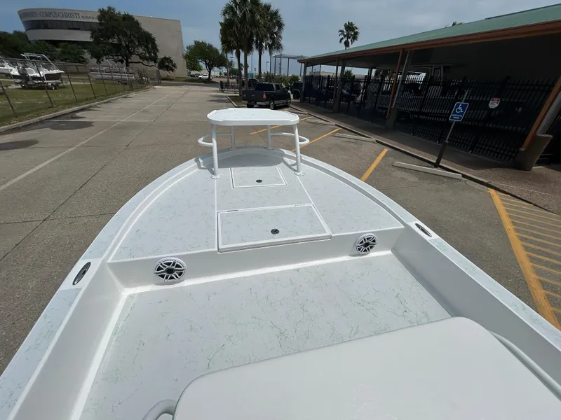 Slide: The Image of 2023 Shallow Sport 21 Sport boat on trailer, parked in a lot with palm trees nearby. - 14