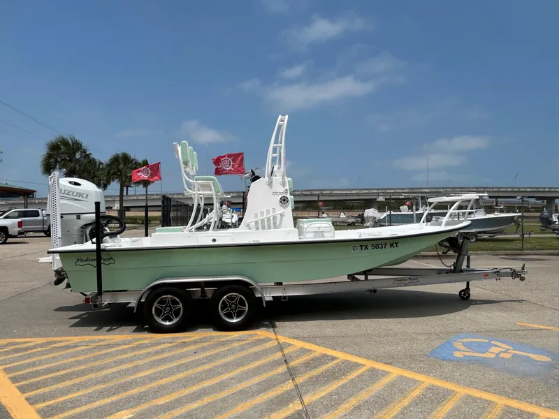 Slide: The Image of 2023 Shallow Sport 21 Sport boat on trailer, parked outdoors under clear sky. - 3