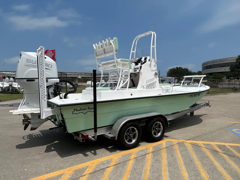 Slide: The Image of 2023 Shallow Sport 21 Sport boat on trailer, featuring Suzuki outboard motor. - 4