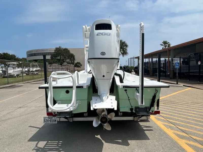 Slide: The Image of 2023 Shallow Sport 21 Sport boat with powerful outboard motor, parked outdoors. - 5