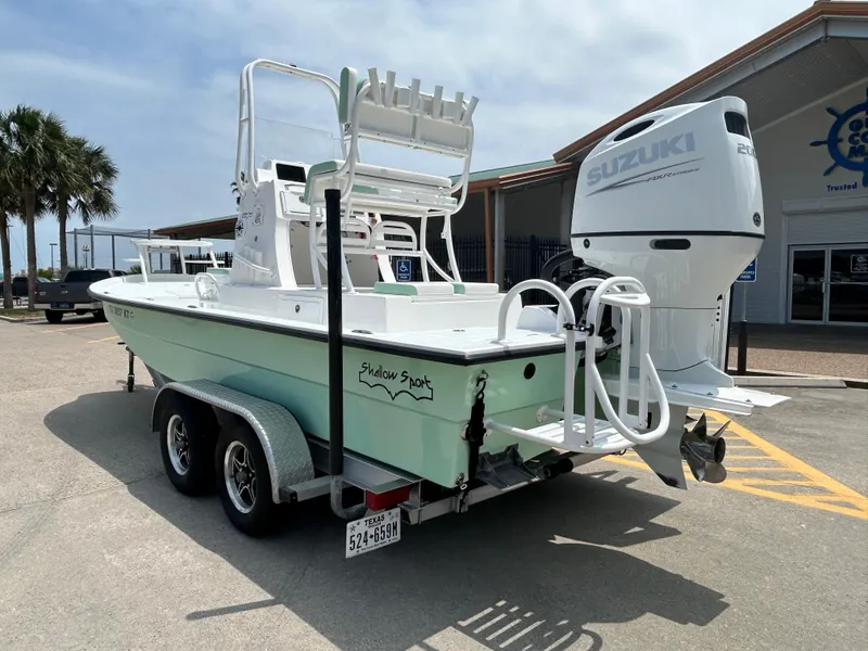Slide: The Image of 2023 Shallow Sport 21 Sport boat with Suzuki engine on a trailer, parked outdoors. - 6