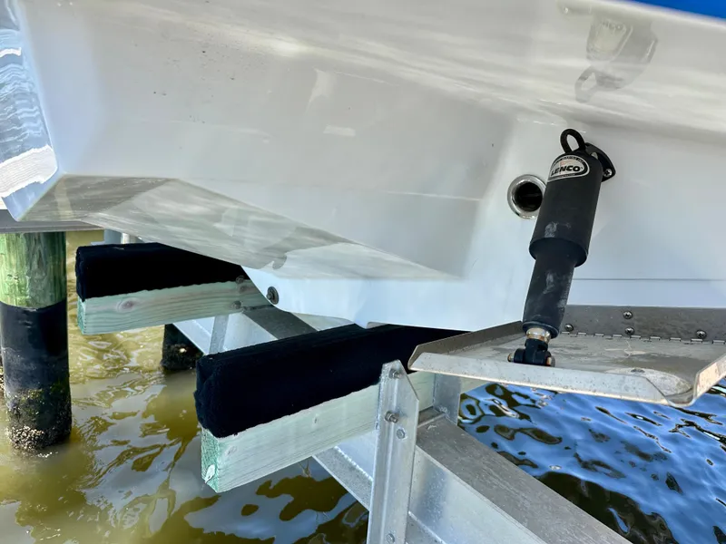 Slide: The Image of 2019 Monterey M45 boat hull on lift, showing outboard motor mount and water reflection. - 11