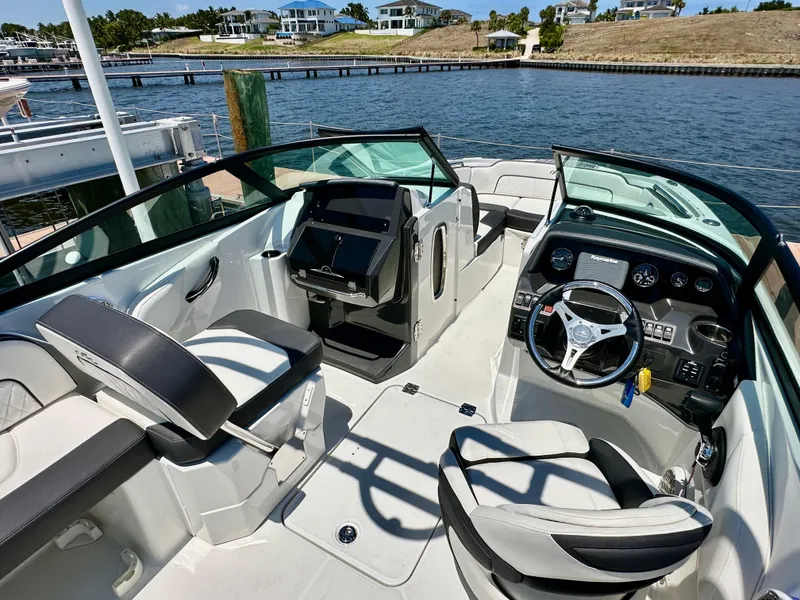 Slide: The Image of 2019 Monterey M45 boat interior with modern dashboard and seating, docked by a scenic waterfront. - 16