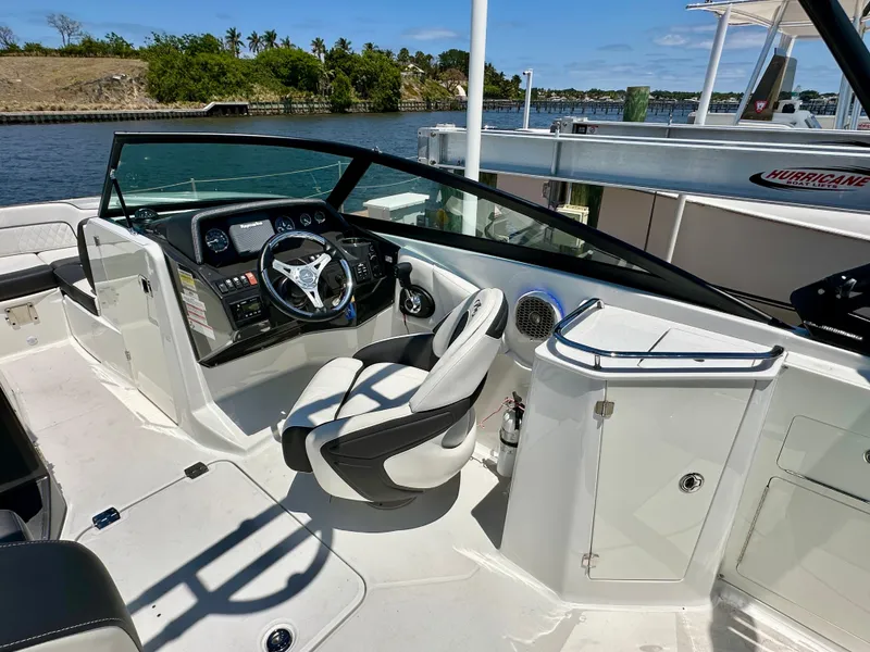 Slide: The Image of 2019 Monterey M45 boat cockpit with steering wheel, dashboard, and seating, docked by the water. - 17