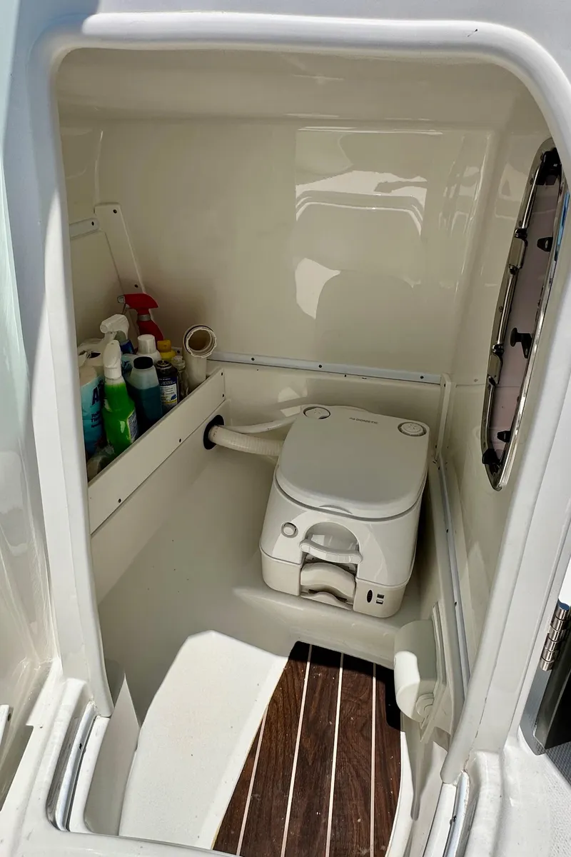 Slide: The Image of 2019 Monterey M45 boat interior with compact marine toilet and cleaning supplies. - 25