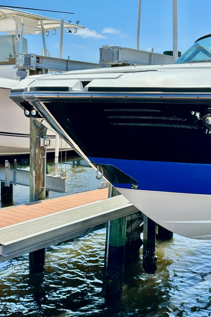 Slide: The Image of 2019 Monterey M45 boat docked at marina, featuring sleek black and blue hull design. - 5