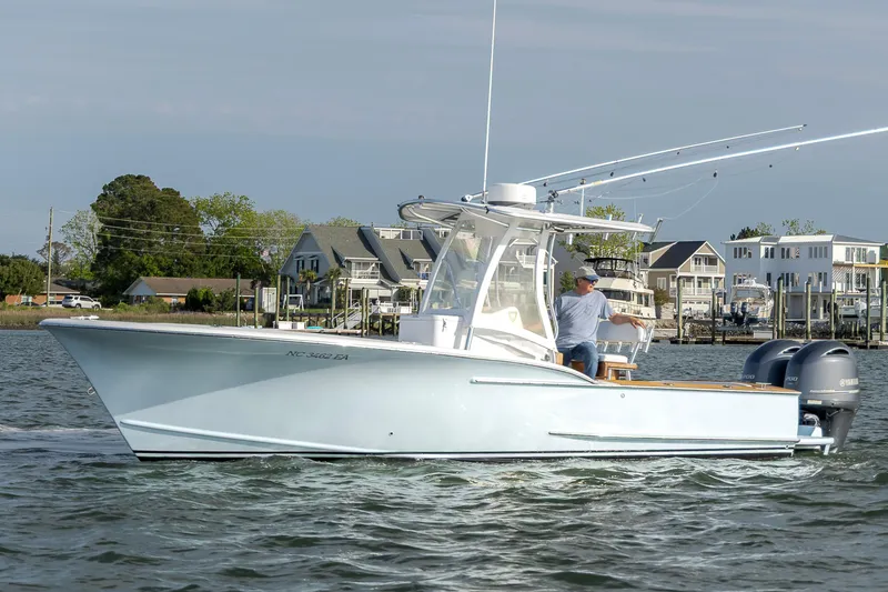 Slide: The Image of 2003 Shearline 23 Center Console boat cruising on water near coastal homes. - 1