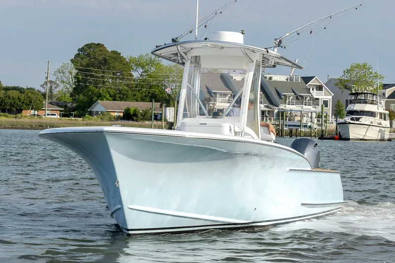 Slide: The Image of 2003 Shearline 23 Center Console boat cruising on water near coastal homes. - 11