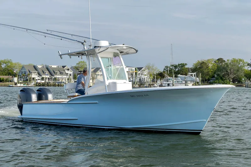 Slide: The Image of 2003 Shearline 23 Center Console boat cruising on a calm waterway near residential area. - 14
