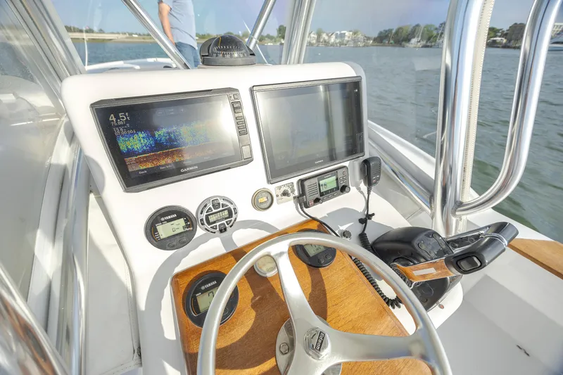 Slide: The Image of 2003 Shearline 23 Center Console boat dashboard with navigation equipment and steering wheel. - 15