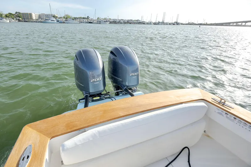 Slide: The Image of 2003 Shearline 23 Center Console with twin outboard motors on a calm sea. - 17