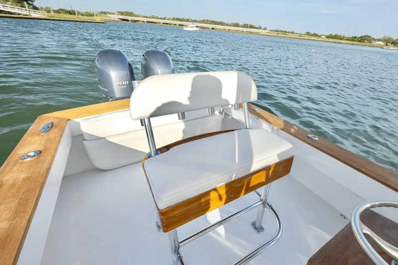 Slide: The Image of 2003 Shearline 23 Center Console boat with dual engines on a calm lake. - 19