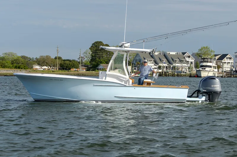 Slide: The Image of 2003 Shearline 23 Center Console boat on water near coastal buildings. - 3