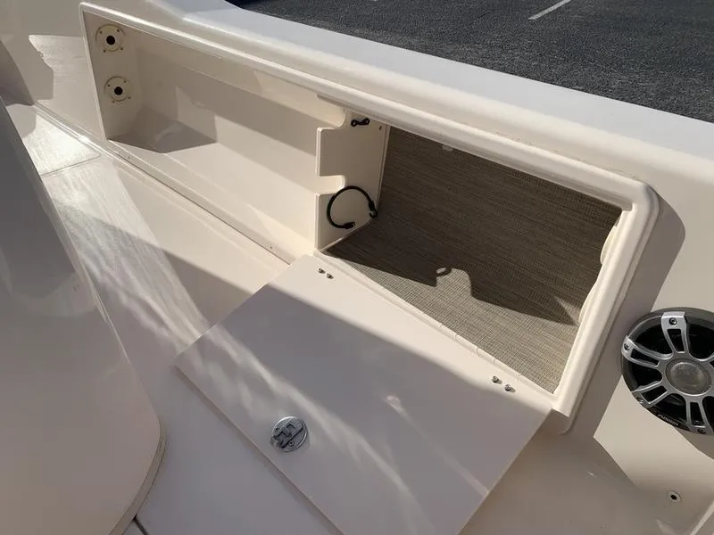 Slide: The Image of 2023 Grady-White 251 Coastal Explorer boat storage compartment with open hatch and speaker. - 14