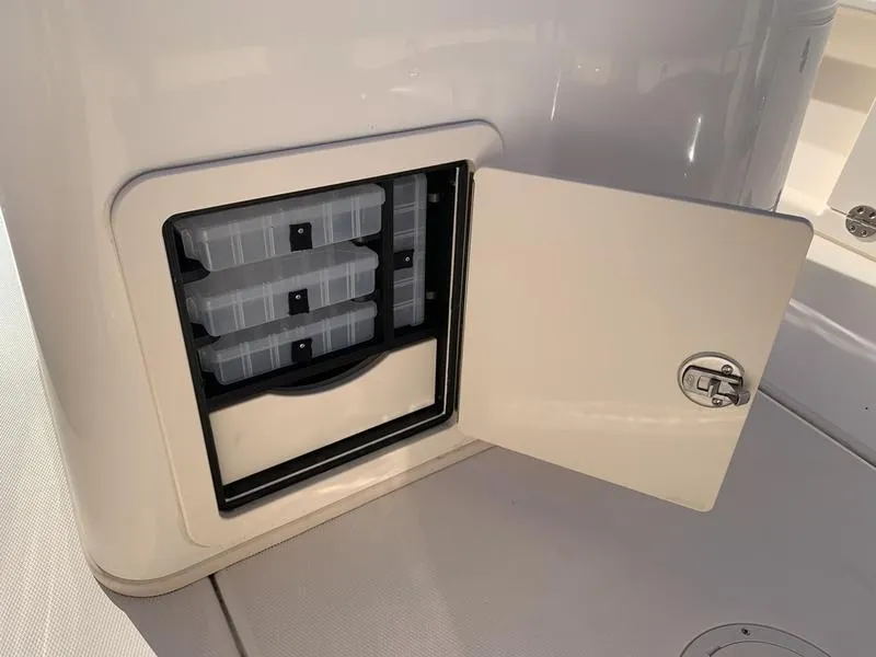 Slide: The Image of Storage compartment on 2023 Grady-White 251 Coastal Explorer boat, featuring organized tackle boxes. - 17