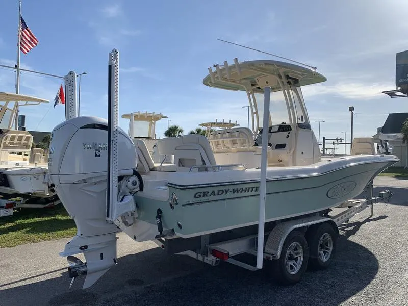 Slide: The Image of 2023 Grady-White 251 Coastal Explorer boat on trailer, displayed outdoors with flags. - 3