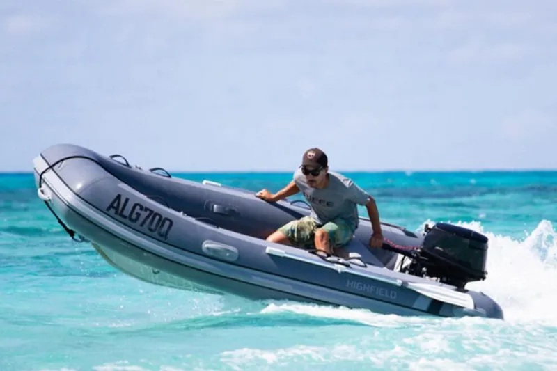 Slide: The Image of Man navigating 2025 Highfield Classic 310 inflatable boat on turquoise ocean waters. - 4
