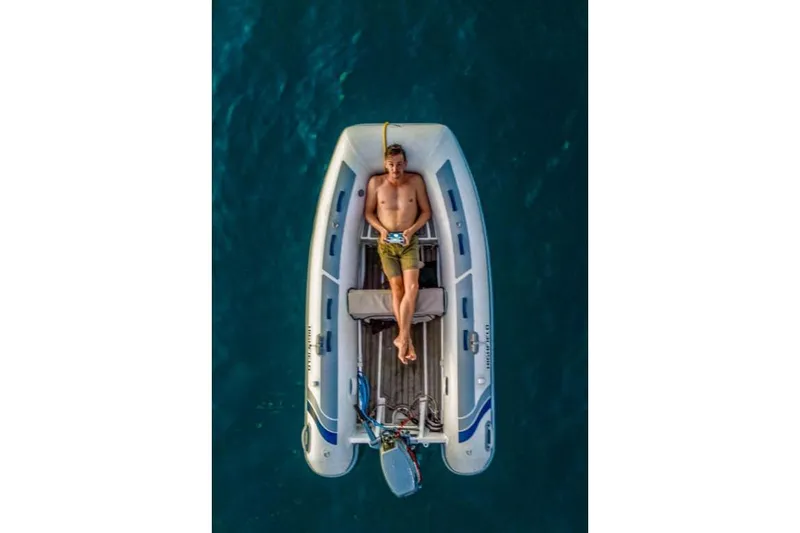 Slide: The Image of Man relaxing on a 2025 Highfield Classic 310 boat in open water. - 6