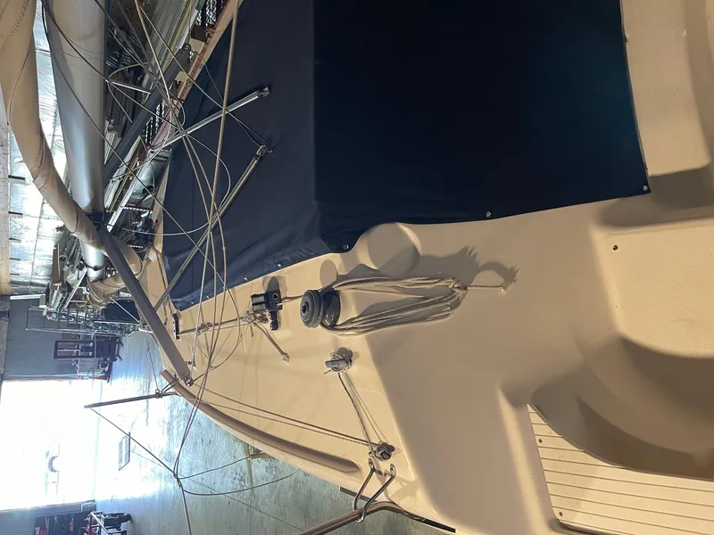 Slide: The Image of 2002 Hunter 260 sailboat with trailer, docked indoors, showcasing deck and rigging. - 36