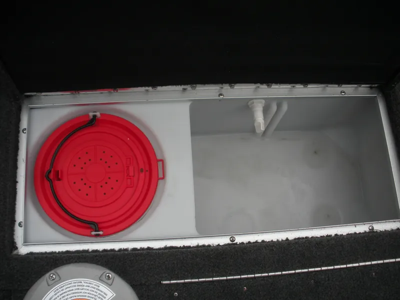 Slide: The Image of 2024 Smoker Craft Excursion Pro 176 DC Pro boat storage compartment with red lid and plumbing. - 8
