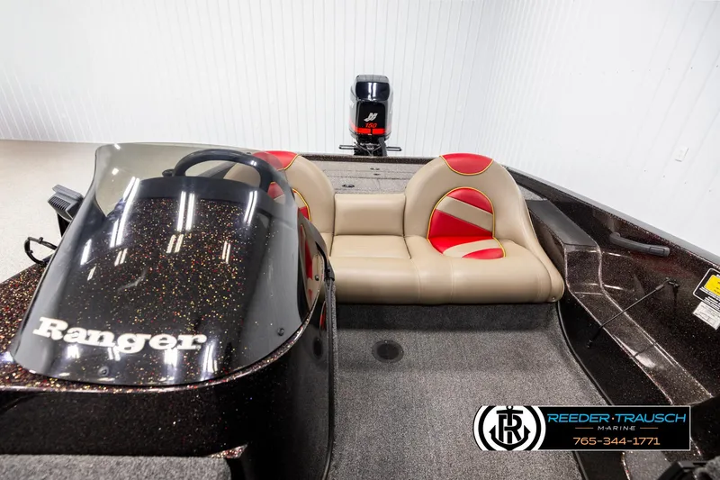 Slide: The Image of 2001 Ranger R81 boat interior with beige and red seating, steering console, and visible motor. - 16