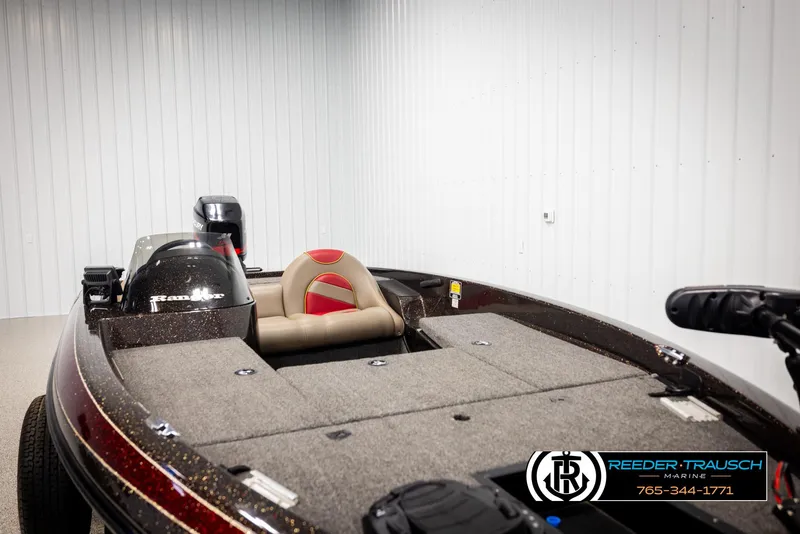 Slide: The Image of 2001 Ranger R81 boat with motor in indoor storage, featuring a red and gray design. - 20