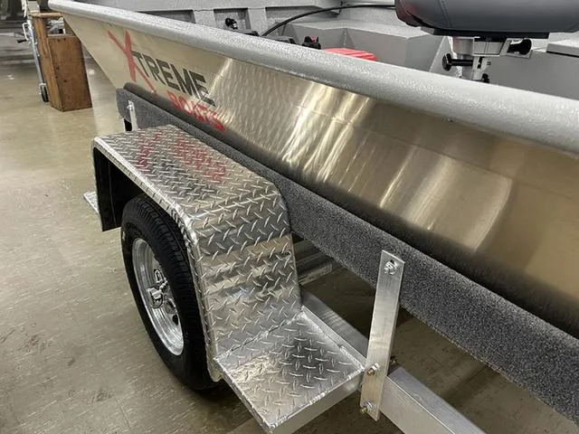 Slide: The Image of 2025 XTREME BOATS River Skiff 1542SS on trailer, featuring aluminum hull and diamond plate fender. - 4