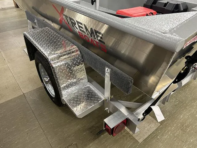 Slide: The Image of 2025 XTREME BOATS River Skiff 1542SS on a trailer with diamond plate fender. - 7